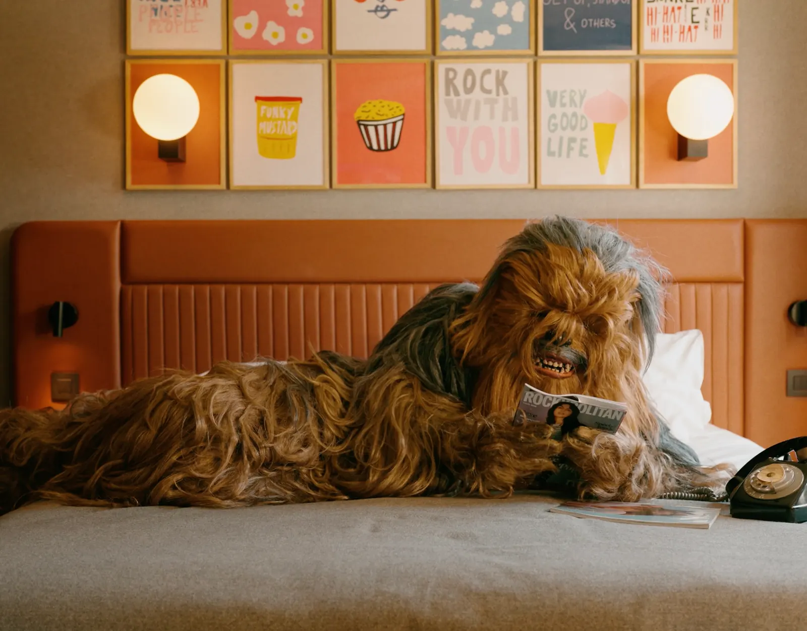 Peluche de Chewbacca allongée sur un lit d’une chambre d’hôtel colorée