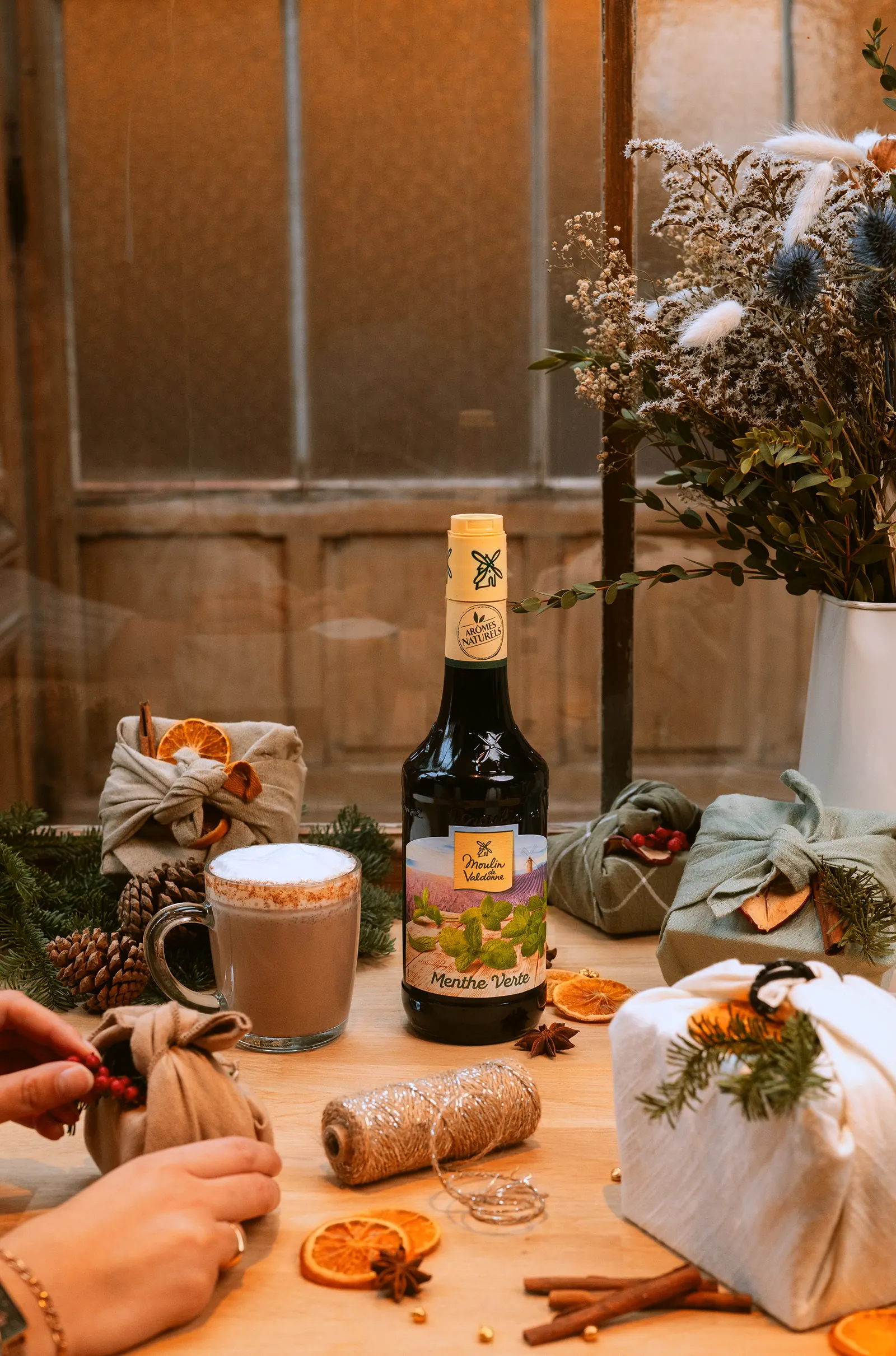 Sirop et boisson chaude au milieu de cadeaux emballés de papier kraft