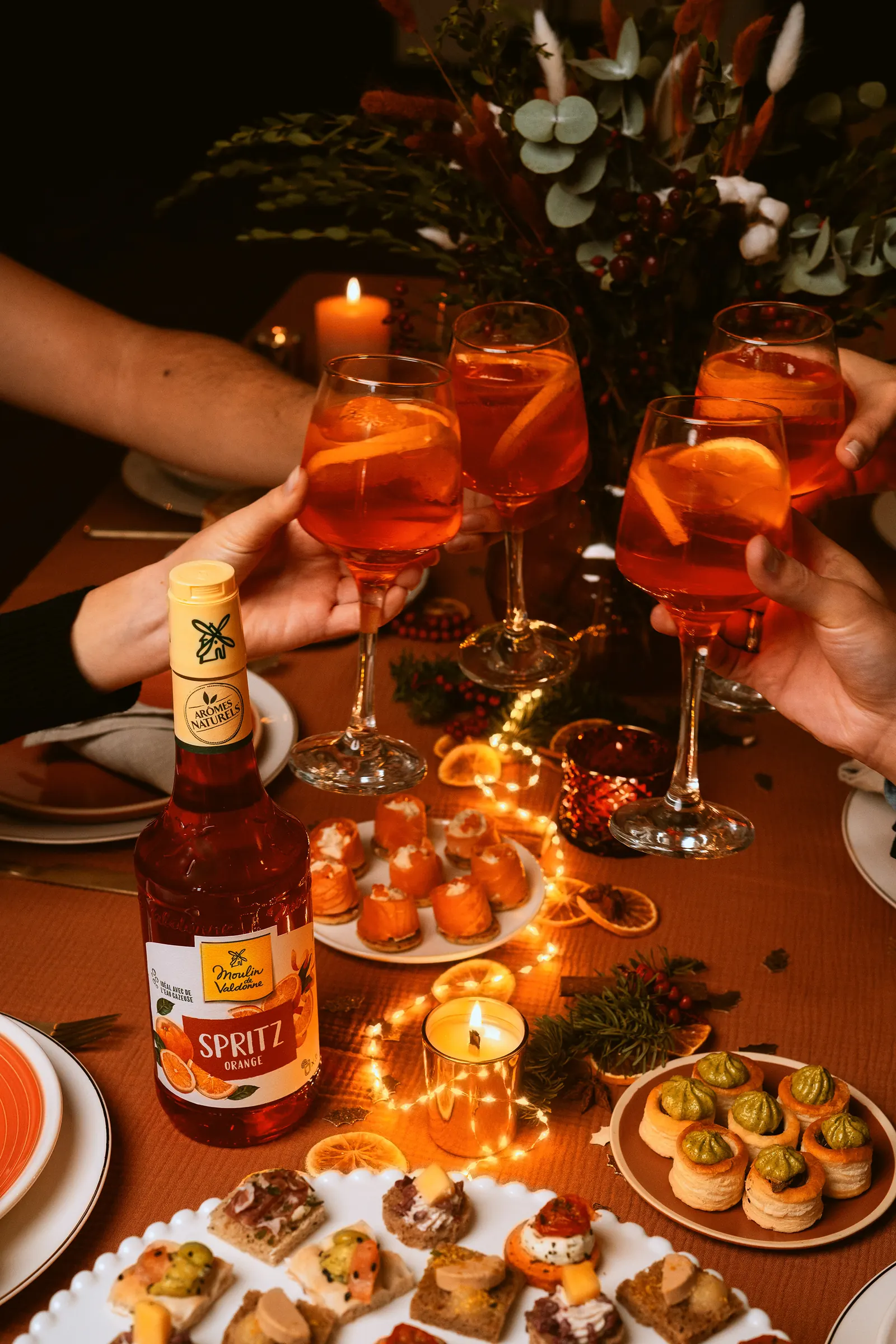 On trinque au spritz autour d’une table de fête aux bougies allumées