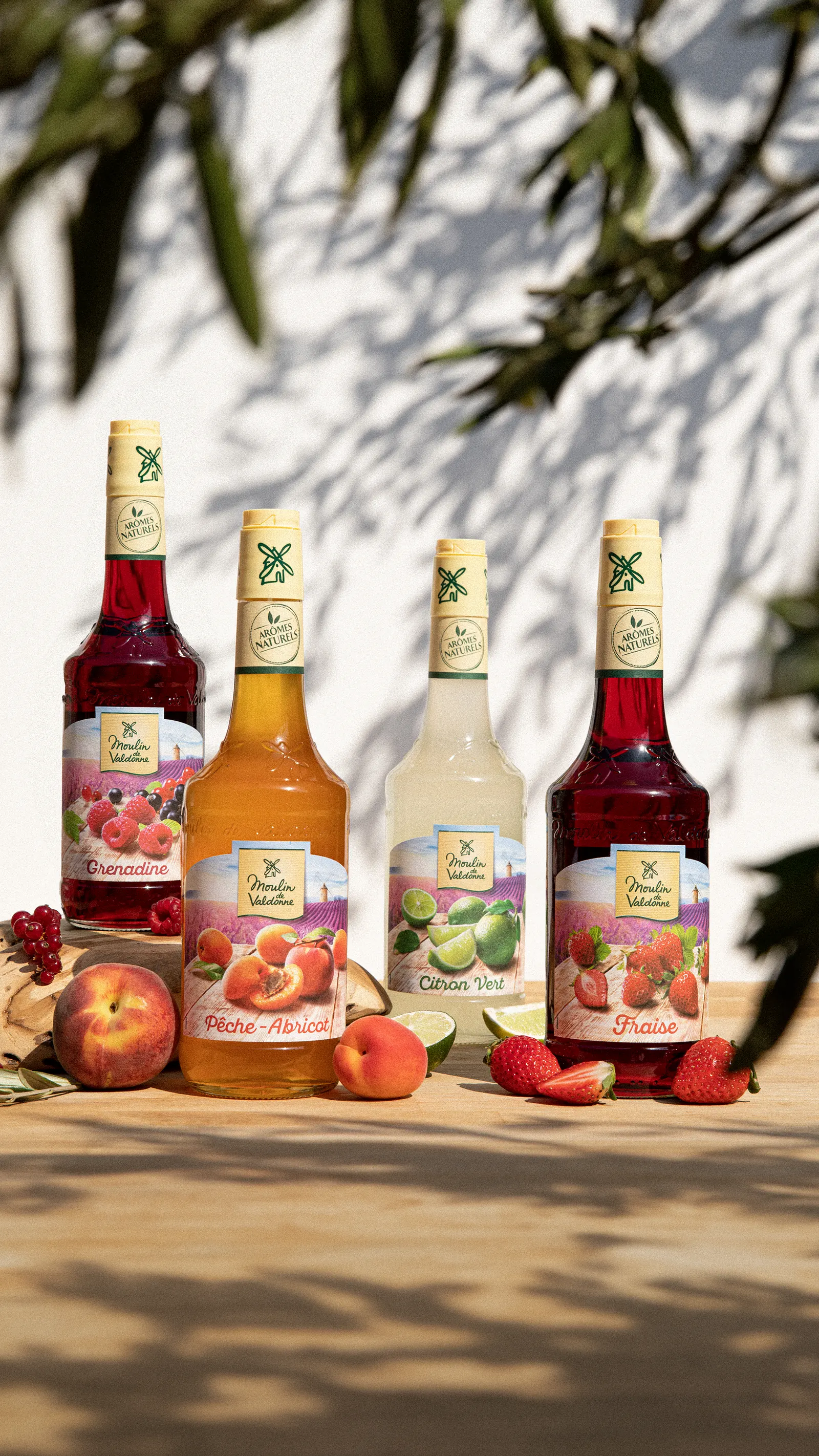 Quatre bouteilles de sirop Moulin de Valdonne alignées au soleil